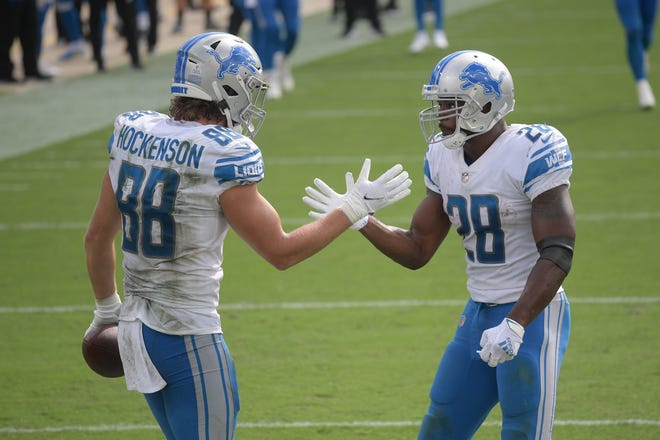 Lions tight end T.J. Hockenson (88) celebrates his touchdown reception against the Jaguars with running back Adrian Peterson (28) during the second half.