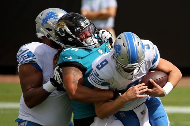 Jaguars defensive end Jabaal Sheard, center, sacks Lions quarterback Matthew Stafford (9) as offensive tackle Tyrell Crosby, left, tries to help during the first half.