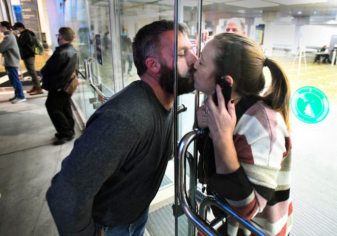 Jason Smith, Detroit, kisses his wife Nicole Smith, an election challenger, through a chained doorway at the TCF Center, where ballots are being counted in the 2020 presidential election in Detroit, on their 20-year anniversary, "Yeah, this is what I am doing on our anniversary," said Nicole.