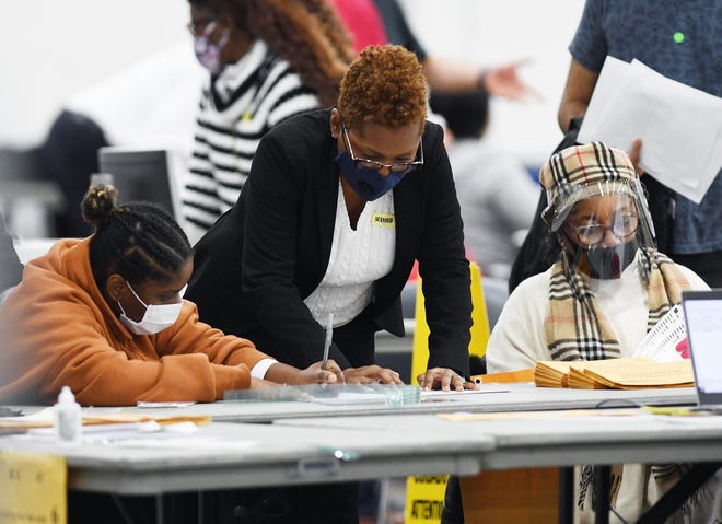 Poll inspectors count and process absentee ballots at the TCF Center in Detroit Wednesday.