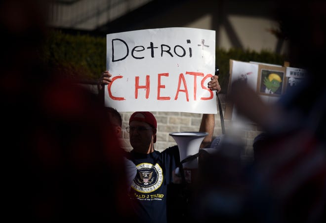 A protester holds a sign during a count protest in front of TCF Center in Detroit, Friday, Nov. 6, 2020.