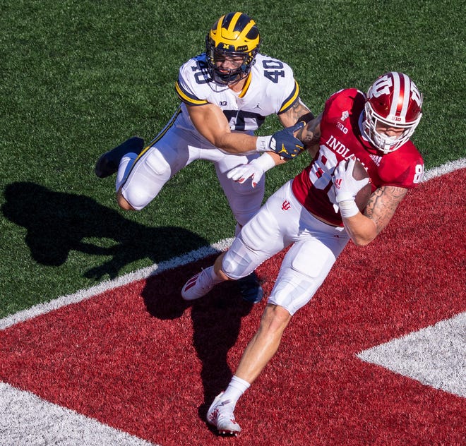 Indiana tight end Peyton Hendershot (86) crosses into the end zone to score ahead of Michigan linebacker Ben VanSumeren (40) during the first half.