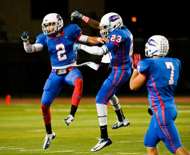 Leander's Greg Kelley (2), Martin Nwakamma (23) and Michael Epley (7) celebrate a defensive stop. All three players made verbal commitments to play college football.