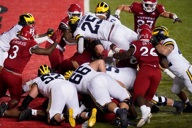Michigan's Hassan Haskins (25) dives into the end zone for a touchdown during the third overtime of the team's NCAA college football game against Rutgers on Saturday, Nov. 21, 2020, in Piscataway, N.J. Michigan won 48-42 in three overtimes.