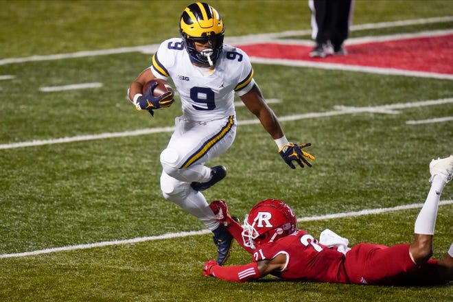 Michigan's Chris Evans (9) avoids a tackle attempt by Rutgers' Tre Avery (21) during the first half.