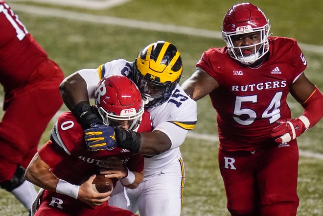 Michigan's Christopher Hinton (15) gets past Rutgers offensive lineman Cedrice Paillant (54) to sack quarterback Noah Vedral (0) during the first half.
