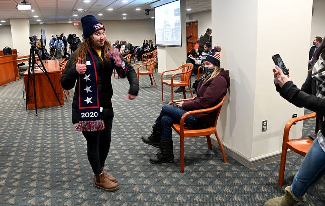 A Rudy Giuliani fan poses for a social media picture before the House Oversight Committee met in Lansing.