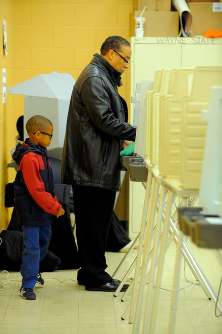 Detroit Mayoral candidate Benny Napoleon votes as his grandson Malachi Jackson 6, looks on, November 5, 2013, at the Charles R. Drew Transition Center in Detroit.