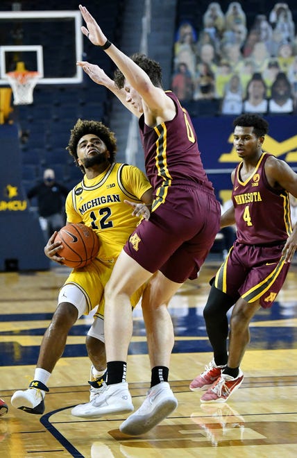 Michigan guard Mike Smith (12) drives on Minnesota center Liam Robbins (0) in the first half.  Michigan vs Minnesota at Crisler Center in Ann Arbor, Mich. on Jan. 6, 2021.