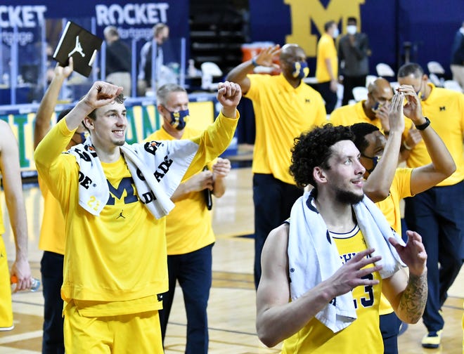 Michigan players Franz Wagner, left, and Brandon Johns Jr., front, cheer at the family and fans after the win.   Michigan vs Minnesota at Crisler Center in Ann Arbor, Mich. on Jan. 6, 2021.  Michigan wins, 82-57.