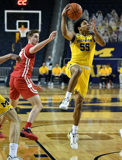 Michigan guard Eli Brooks (55) goes to the basket in front of Wisconsin forward Nate Reuvers (35) in the first half.