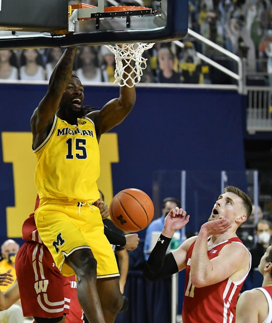 Michigan guard Chaundee Brown (15) dunks in front of Wisconsin forward Micah Potter (11) in the second half.  Michigan wins, 77-54.