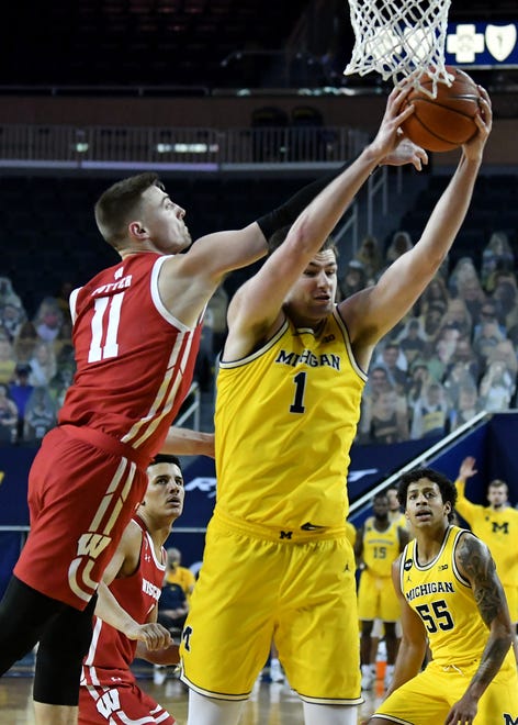 Michigan center Hunter Dickinson (1) pulls down a rebound in front of Wisconsin forward Micah Potter (11) in the second half.
