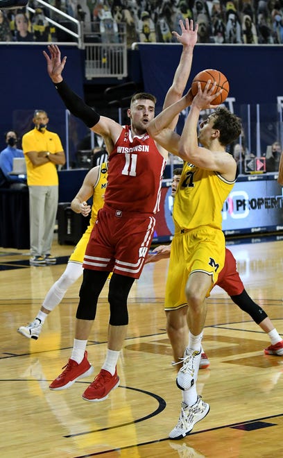 Michigan guard Franz Wagner (21) drives on Wisconsin forward Micah Potter (11) in the second half.  Michigan vs Wisconsin at Crisler Center in Ann Arbor, Mich. on Jan. 12, 2021.  Michigan wins, 77-54.