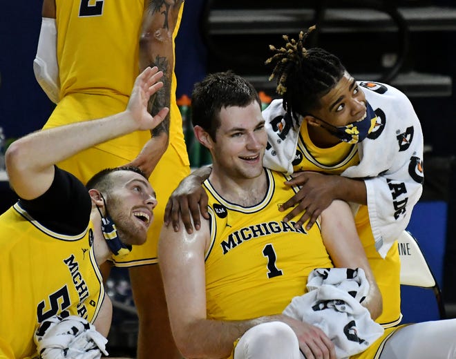 Michigan's Austin Davis, left, and Mike Smith joke around with Hunter Dickinson (1) while Dickenson is being shown on the scoreboard in the second half.  Michigan vs Wisconsin at Crisler Center in Ann Arbor, Mich. on Jan. 12, 2021.  Michigan wins, 77-54.