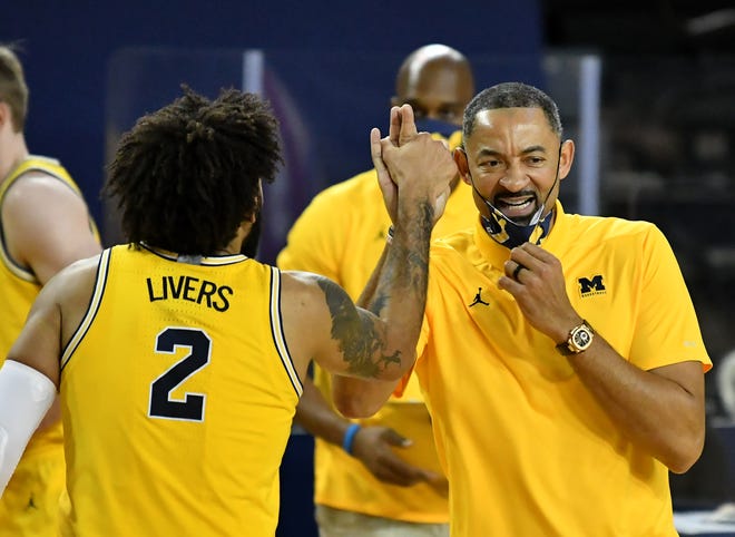 Michigan head coach Juwan Howard talks with forward Isaiah Livers (2) as he exits the game in the second half.