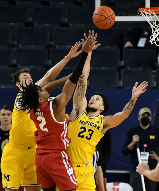 Michigan's Franz Wagner (21) and forward Brandon Johns Jr. (23) converge on Wisconsin forward Aleem Ford (2) in the second half.  Michigan vs Wisconsin at Crisler Center in Ann Arbor, Mich. on Jan. 12, 2021.  Michigan wins, 77-54.