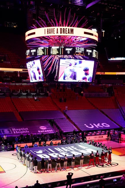 Miami Heat and Detroit Pistons players hold a "I Have a Dream" banner in honor of the Martin Luther King Jr., holiday before an NBA basketball game, Monday, Jan. 18, 2021, in Miami.
