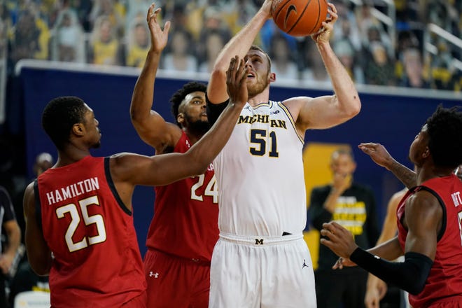 Michigan forward Austin Davis (51) is defended by Maryland forwards Jairus Hamilton (25) and Donta Scott (24) during the second half.