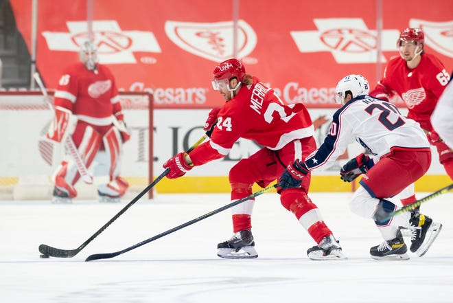 Detroit defenseman Jon Merrill keeps the puck away from Columbus center Riley Nash in the first period.