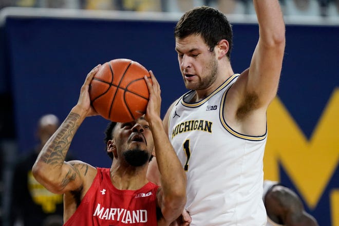 Maryland guard Eric Ayala, left, is defended by Michigan center Hunter Dickinson (1) during the first half.