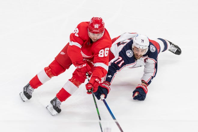 Detroit left wing Mathias Brome and Columbus left wing Nick Foligno battle for the puck in the second period.