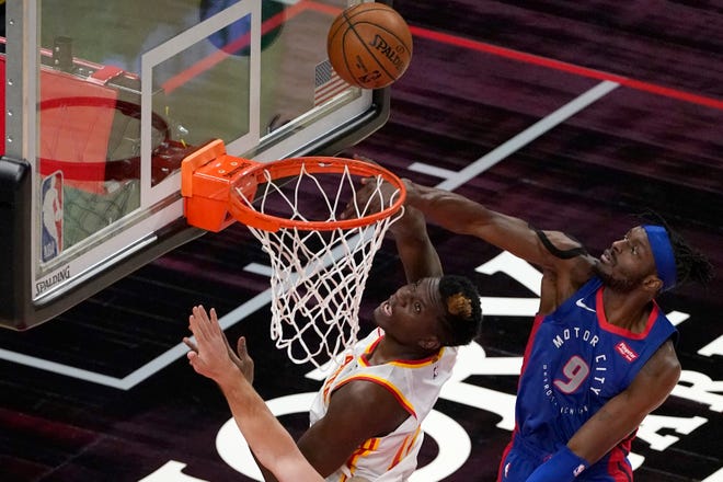 Atlanta Hawks center Clint Capela (15) and Detroit Pistons forward Jerami Grant (9) look for a rebound during the first half of an NBA basketball game Wednesday, Jan. 20, 2021, in Atlanta.