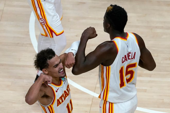 Atlanta Hawks guard Trae Young (11) and center Clint Capela (15) celebrate a basket in overtime of the team's 123-115 victory over the Detroit Pistons in an NBA basketball game Wednesday, Jan. 20, 2021, in Atlanta.