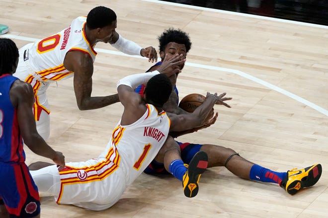Detroit Pistons forward Saddiq Bey (41) covers a loose ball next to Atlanta Hawks' Brandon Goodwin (0) and Nathan Knight (1) during the first half of an NBA basketball game Wednesday, Jan. 20, 2021, in Atlanta.
