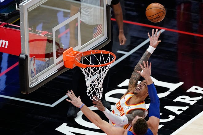 Atlanta Hawks forward John Collins (20) goes in for a shot as Detroit Pistons forward Blake Griffin defends during the first half of an NBA basketball game Wednesday, Jan. 20, 2021, in Atlanta.