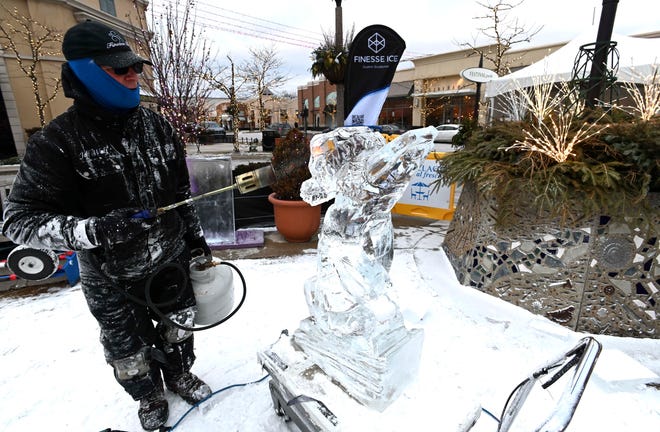 Finesse Ice owner Jeff Wolf uses a torch to melt away excess snow which makes the ice clear.