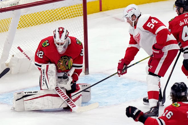 Chicago Blackhawks goalie Kevin Lankinen, left, blocks a shot by Detroit Red Wings right wing Bobby Ryan during the second period.