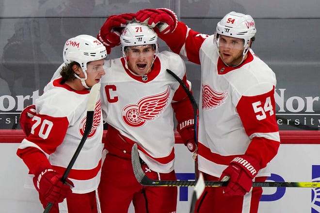 Detroit Red Wings center Dylan Larkin, center, celebrates with defender Troy Stecher, left, and right wing Bobby Ryan after scoring a goal during the third period of an NHL hockey game against the Chicago Blackhawks in Chicago, Friday, Jan. 22, 2021. (AP Photo/Nam Y. Huh)