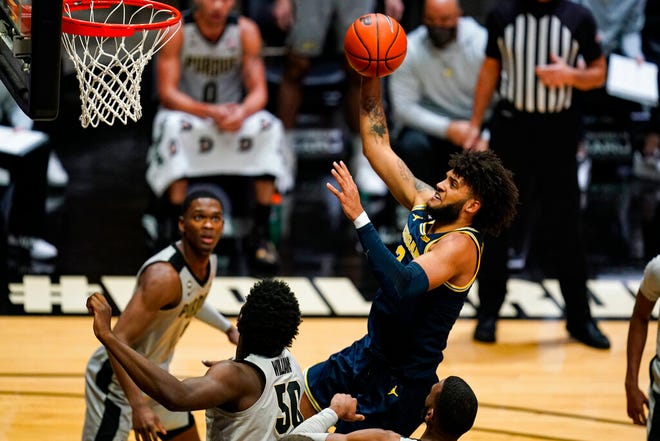Michigan forward Isaiah Livers (2) shoots over Purdue forward Trevion Williams (50) during the first half of an NCAA college basketball game in West Lafayette, Ind., Friday, Jan. 22, 2021. (AP Photo/Michael Conroy)