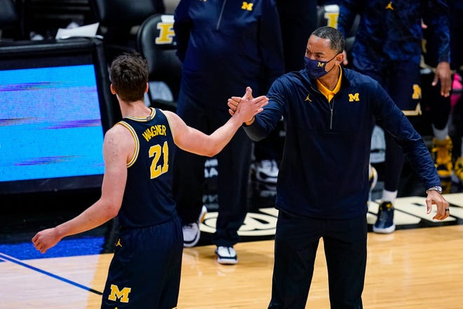 Michigan coach Juwan Howard and guard Franz Wagner (21) celebrate during the first half.