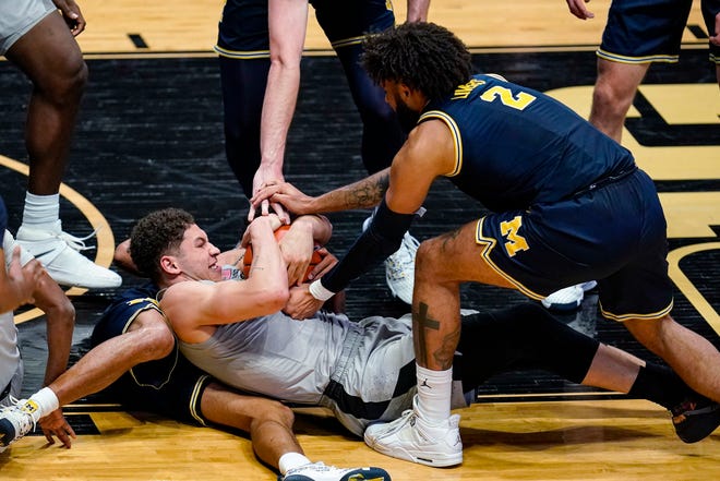 Purdue forward Mason Gillis (0) and Michigan forward Isaiah Livers (2) try to get possession of the ball during the second half.