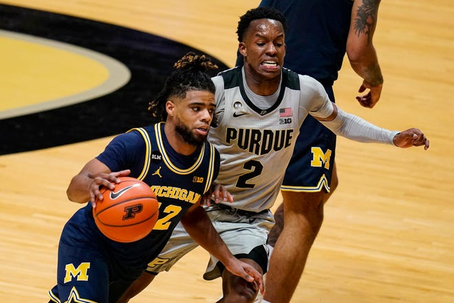 Michigan guard Mike Smith (12) drives on Purdue guard Eric Hunter Jr. (2) during the second half.
