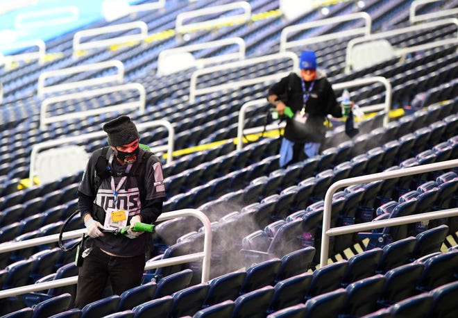Seats are sprayed with disinfectant in between games during the MHSAA football finals at Ford Field in Detroit, Michigan on January 22, 2021.