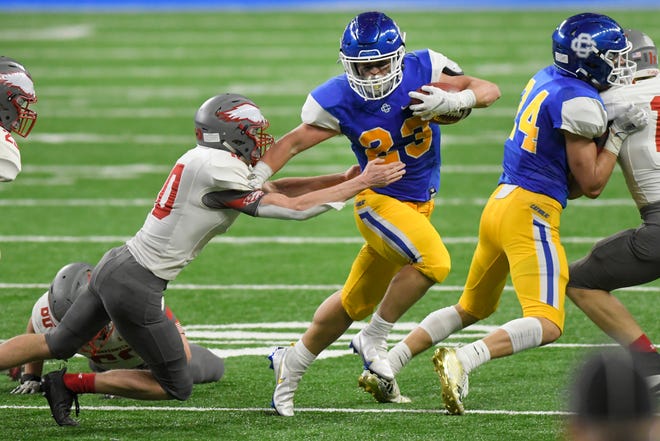 Grand Rapids Catholic Central running back Nick Hollern, right, rushes as he is chased by Frankenmuth defensive back Samuel McKenzie in the third quarter of a Division 5 football final held at Ford Field.