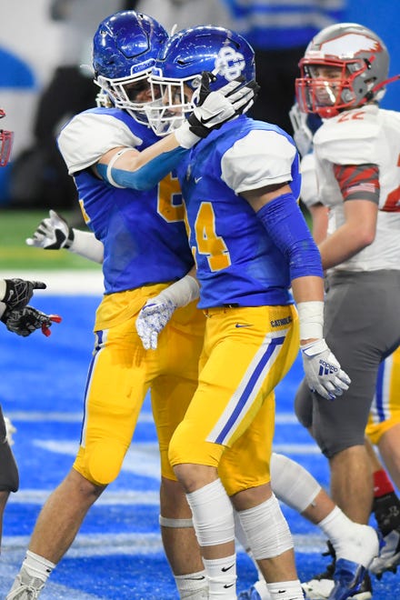 Grand Rapids Catholic Central safety Nolan Ziegler, center, is congratulated by teammates after scoring a touchdown against Frankenmuth in the first half of a Division 5 football final.