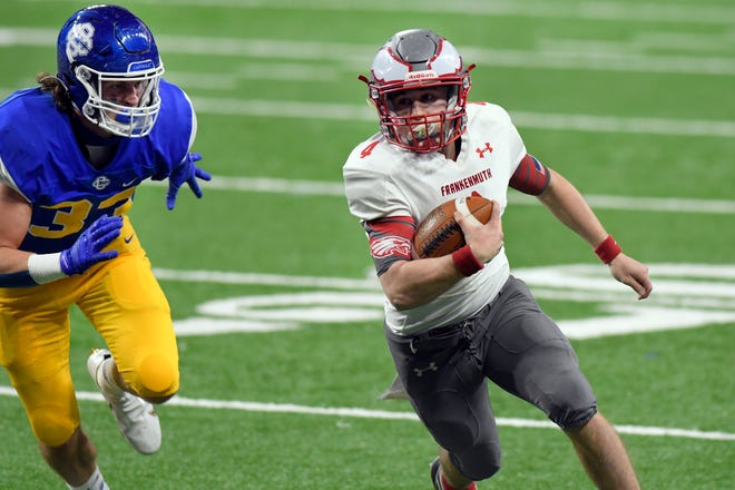 Frankenmuth quarterback Davin Reif, right, rushes for yardage as he is chased by Grand Rapids Catholic Central defenseman Daniel Krajewski  in the first half of a Division 5 football final held at Ford Field.