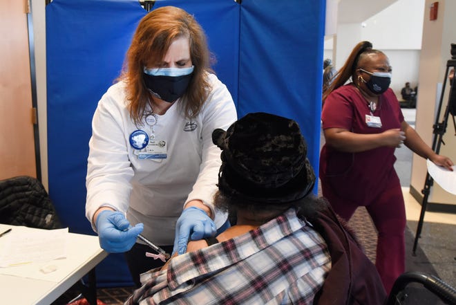 Henry Ford Health System Medical Assistant Kimberly Steenbergh, left, gives the Moderna vaccine to Earline Tolbert of Detroit at Second Ebenezer Church in Detroit, Saturday, Feb. 13, 2021.