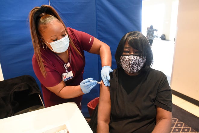 Beverly Beasley of Detroit, seated, gets the Moderna vaccine from Henry Ford Health Medical Assistant Patrice Odom at Second Ebenezer Church in Detroit, Saturday, Feb. 13, 2021.