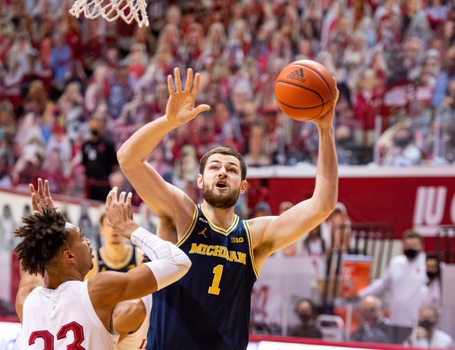 Michigan center Hunter Dickinson (1) shoots over the defense of Indiana forward Trayce Jackson-Davis (23) during the first half of an NCAA college basketball game, Saturday, Feb. 27, 2021, in Bloomington, Ind.