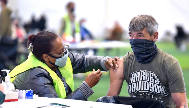 Oakland County Public Health Nurse Sheree Giddings, left, gives a vaccination shot to William Sprankle, of Waterford, Friday, April 2, 2021.