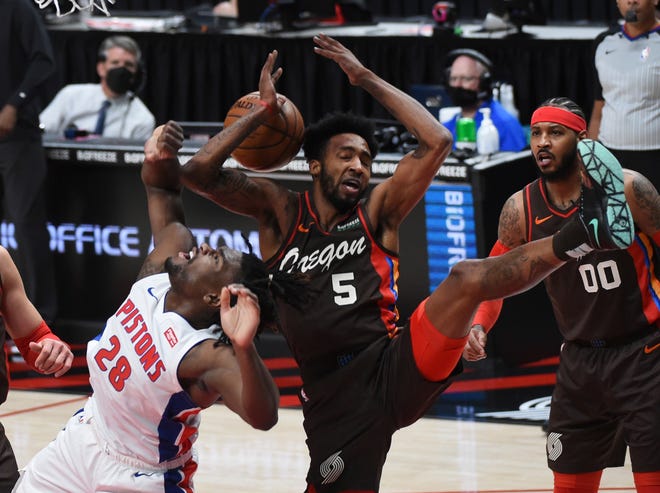 Portland Trail Blazers forward Derrick Jones Jr., center, blocks the shot of Detroit Pistons center Isaiah Stewart, left, during the first half.