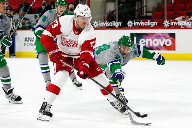 Detroit Red Wings' Adam Erne (73) lifts the puck over the stick of Carolina Hurricanes' Jake Bean (24) to score a goal during the third period.