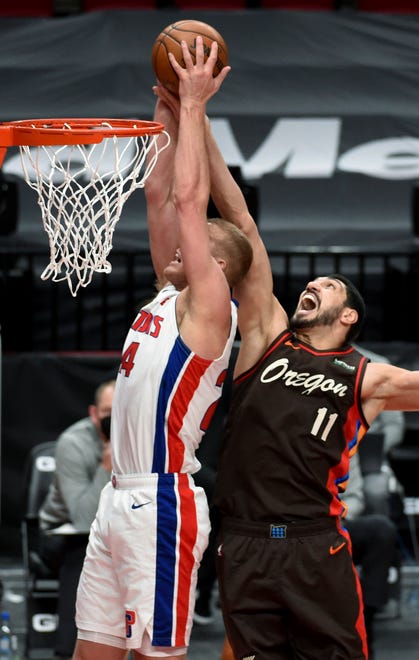 Detroit Pistons center Mason Plumlee, left, and Portland Trail Blazers center Enes Kanter, right go up for a rebound during the first half.