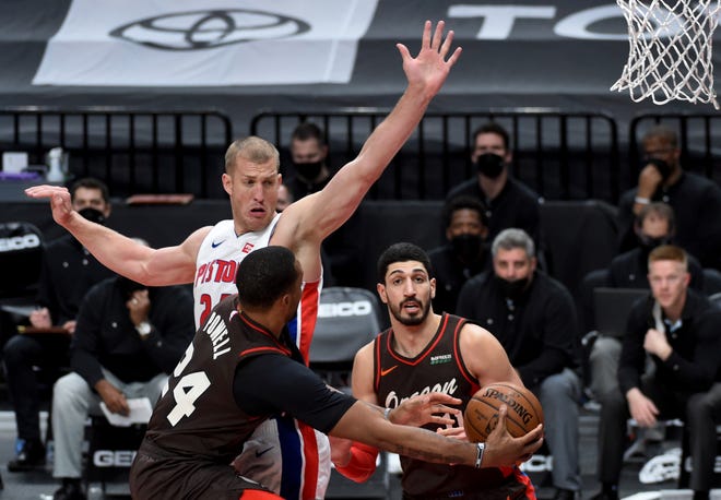 Portland Trail Blazers forward Norman Powell, front left, passes the ball around Detroit Pistons center Mason Plumlee, center, to center Enes Kanter during the second half.