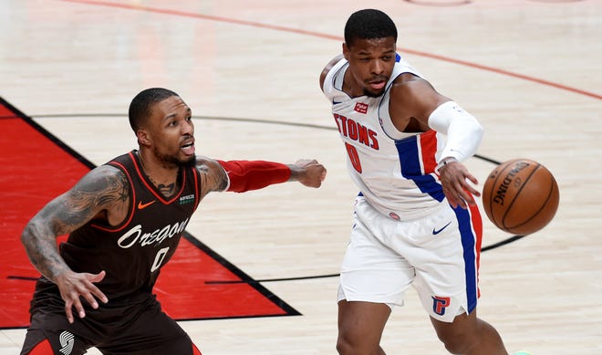 Detroit Pistons guard Dennis Smith Jr., right, pokes the ball away from Portland Trail Blazers guard Damian Lillard during the first half.